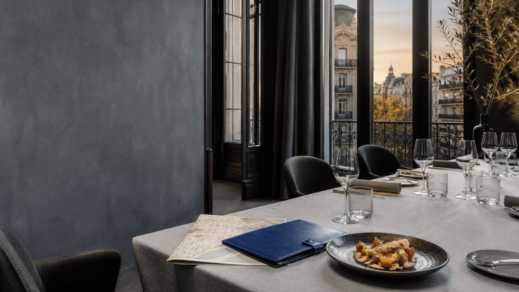 为商务晚餐准备的私人用餐空间，桌上放有 Barcelona 地图与订位资料夹